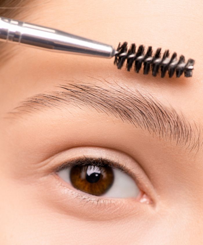 The Art of Drawing Readers In: Your attractive post title goes here A detailed close-up photo of a woman's eyebrow being groomed with a brush.