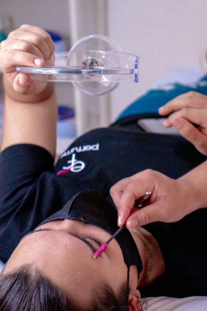 Mastering the First Impression: Your intriguing post title goes here Close-up of a woman lying down receiving an eyebrow care treatment with tools indoors.