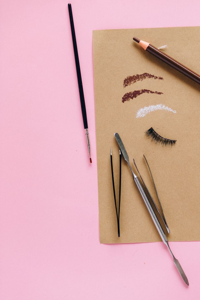 Crafting Captivating Headlines: Your awesome post title goes here A flat lay of cosmetic tools including brushes and tweezers on a pink background.
